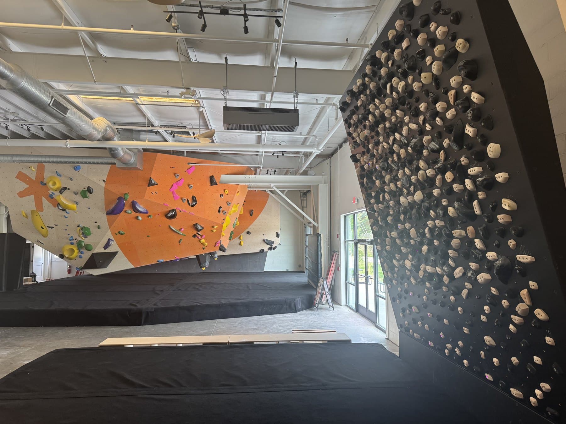 Ripple Boulder's main climbing walls — the orange feature wall and the spray wall, freshly set